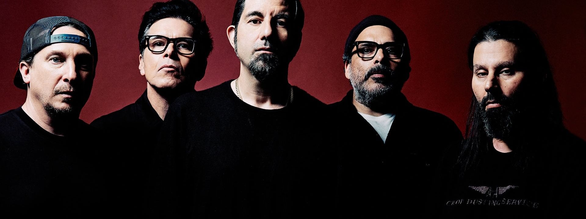 Five men in black clothes standing side by side against red background for Deftones Tour 2026.