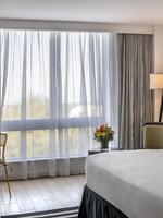 Island View Accessible with White bed by a yellow chair under a black floor lamp at Warwick Paradise Island Bahamas