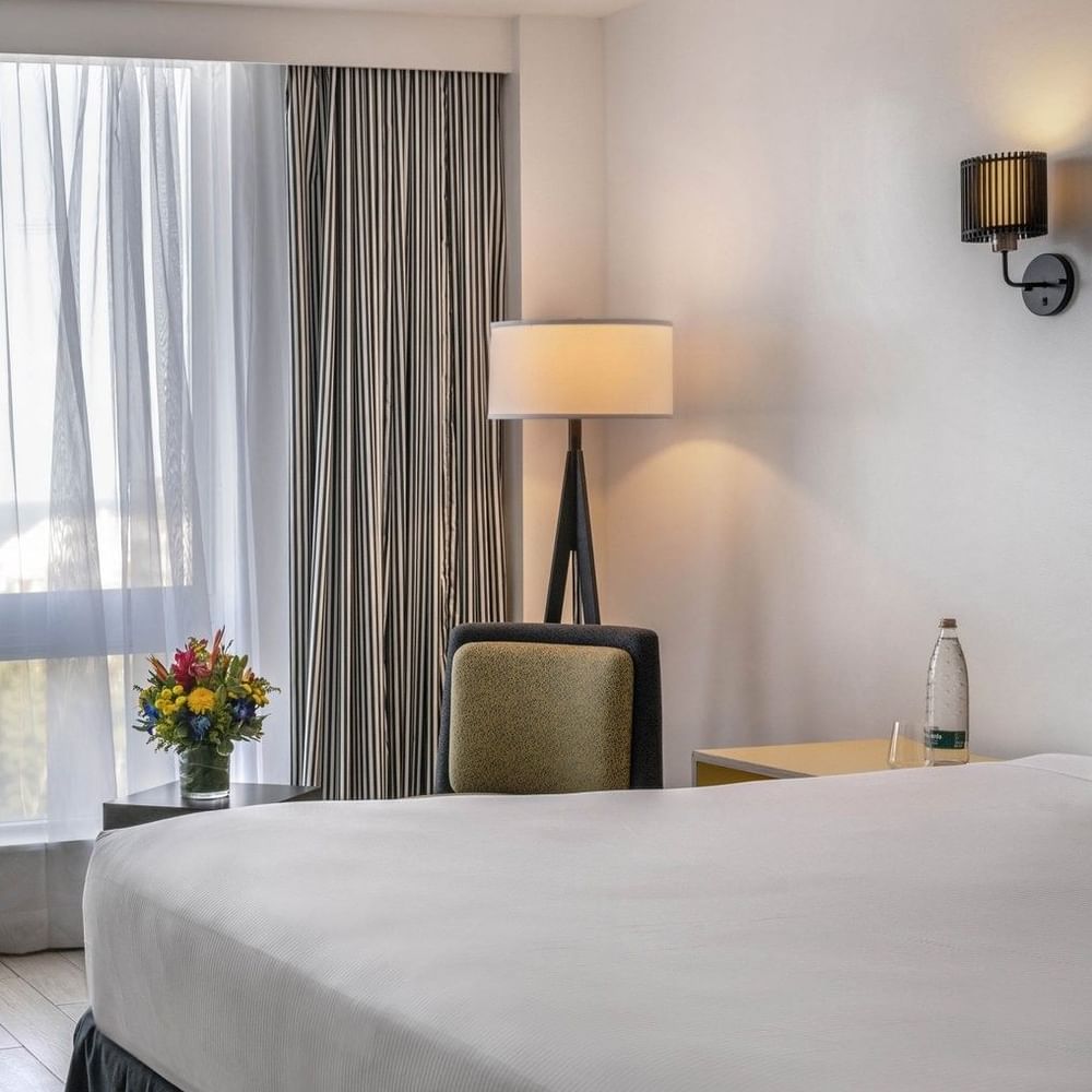 Island View Accessible with White bed by a yellow chair under a black floor lamp at Warwick Paradise Island Bahamas