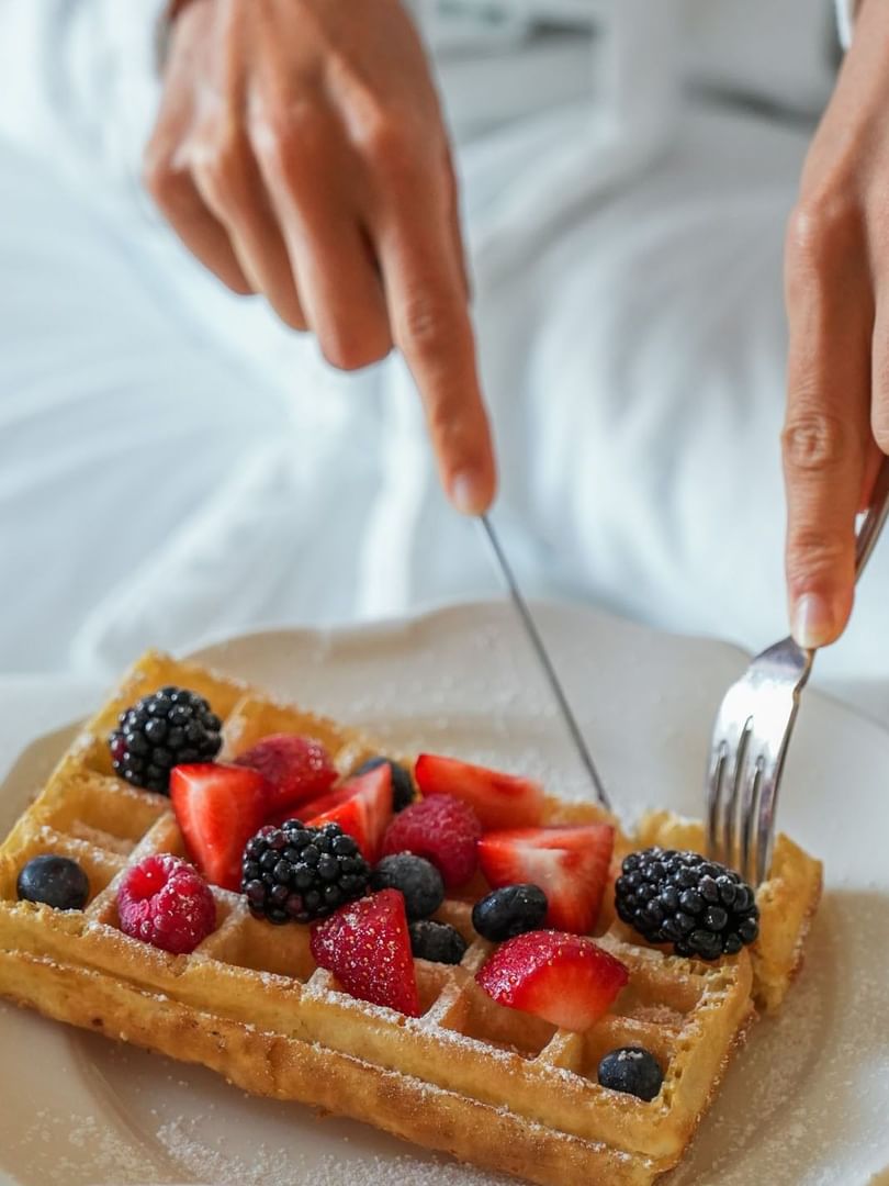 Waffle with fresh mixed berries and powdered sugar served in-room by a guest at Warwick Grand Place Brussels