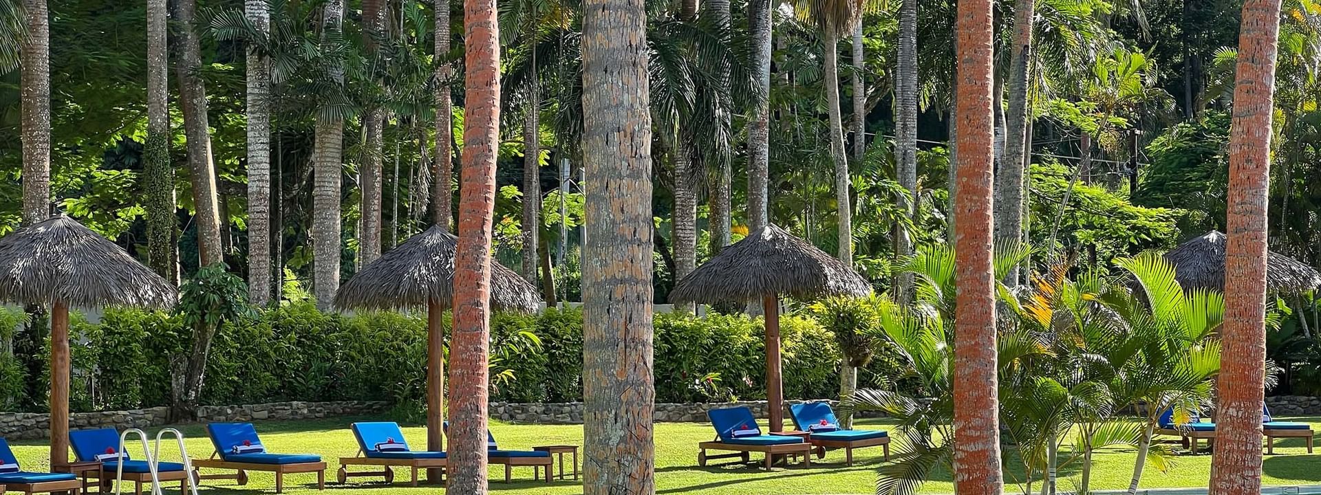 Lounge chairs and umbrellas around a pool at Tambua Sands Beach Resort in Sigatoka