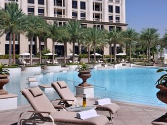 Sunbeds & palm trees by the pool at Palazzo Versace Dubai