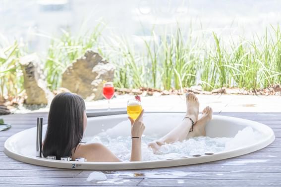 A woman enjoying a soak in a hot tub at Diez Hotel Categoría