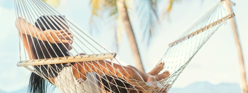 Girl relaxes beside the beach at Pullman Palm Cove Sea Temple Resort & Spa