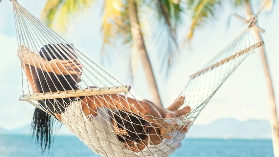 Girl relaxes beside the beach at Pullman Palm Cove Sea Resort