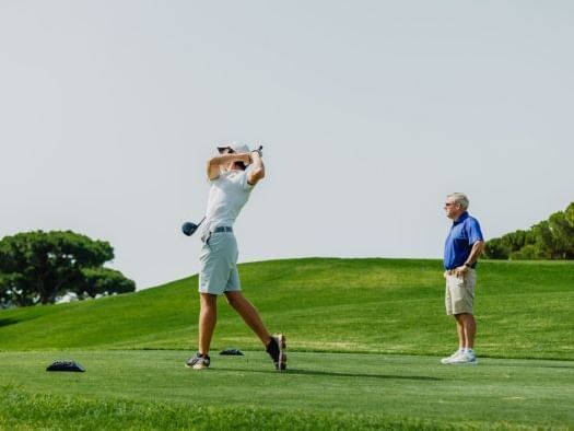 Two men playing golf on the golf course at The Magnolia Hotel