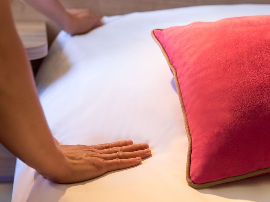 A hotel maid preparing a bed at Le Clos des Tanneurs