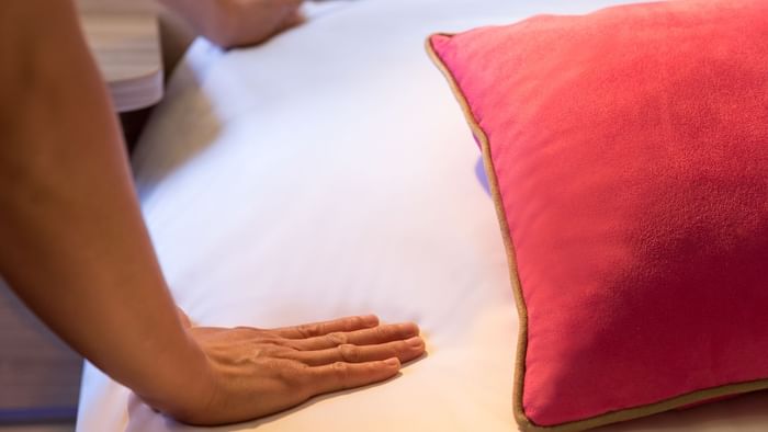 A hotel maid preparing a bed at Le Clos des Tanneurs