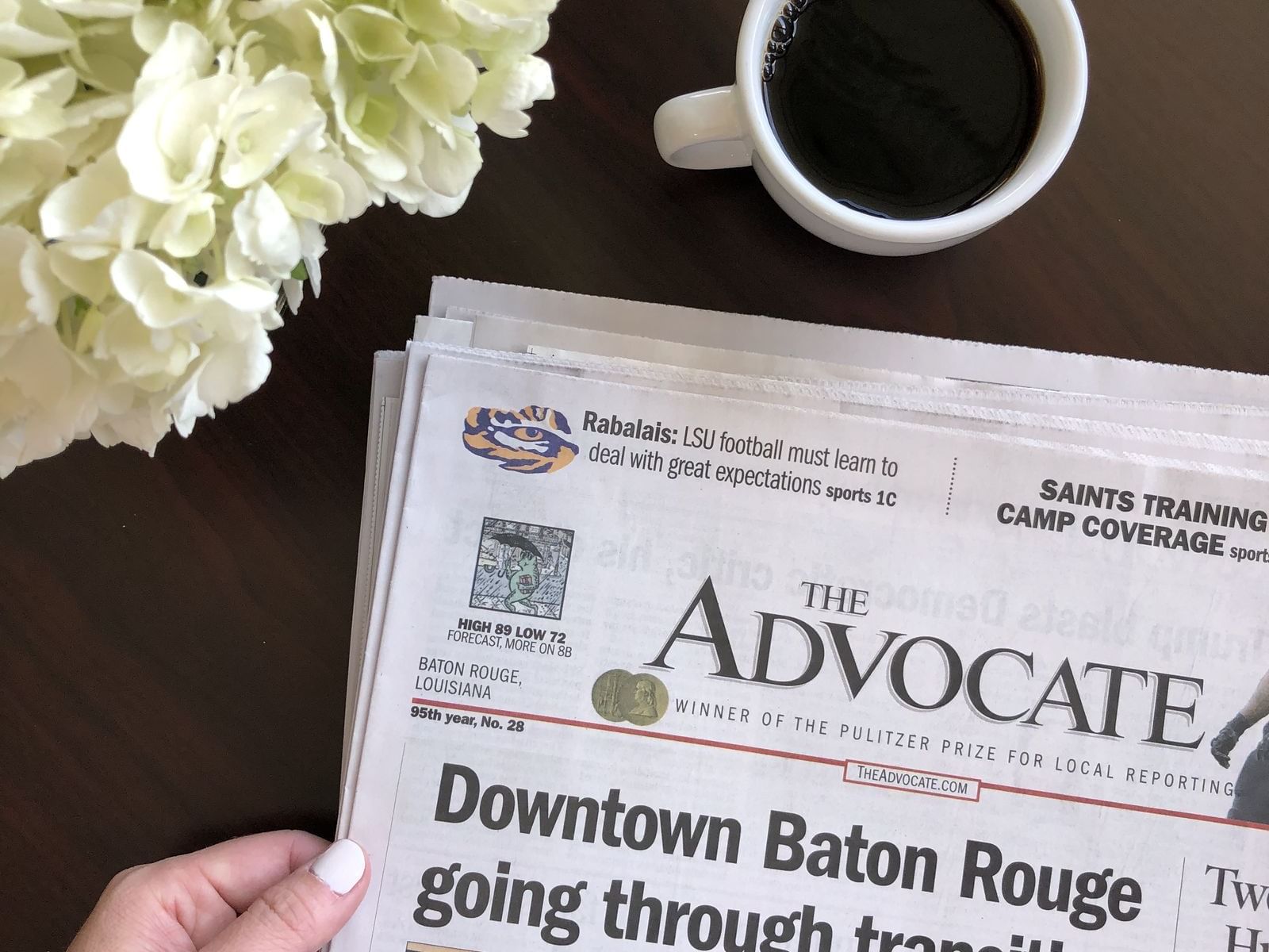 The Advocate newspaper and cup of coffee