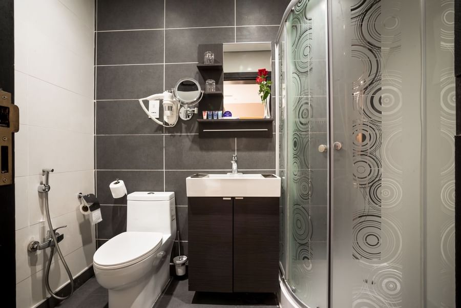 Family Suite bathroom featuring a vanity with a lavatory by the glass shower at Naviti By Warwick Dammam