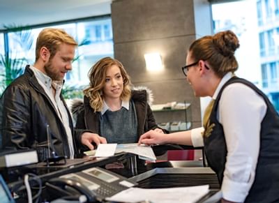 A concierge helps a couple with Checking in at Hotel Sternen