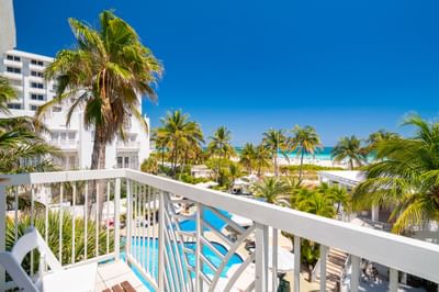 Balcony overlooking the ocean with palm trees in Junior King Oceanfront Suite with Balcony at The Savoy Hotel & Beach Club
