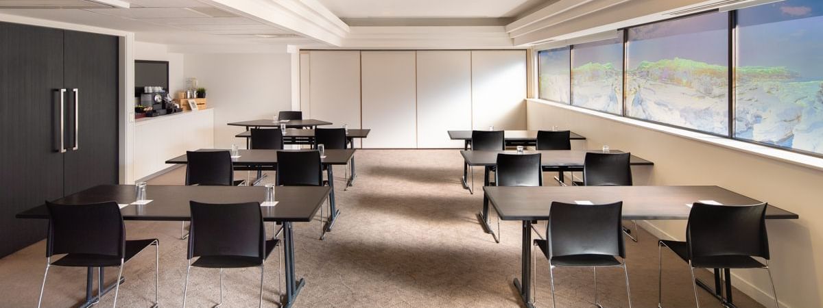 Classroom setup by the large windows in the Acacia Conference Room at Novotel Sydney International Airport
