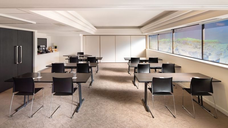 Classroom setup by the large windows in the Acacia Conference Room at Novotel Sydney International Airport