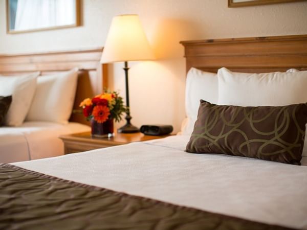 Two beds in hotel room with flowers