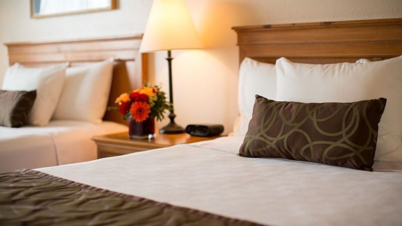 Two beds in hotel room with flowers