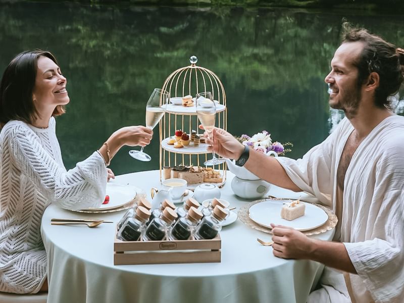 Couple enjoying Afternoon Tea by the lake at The Banjaran Hotsprings Retreat