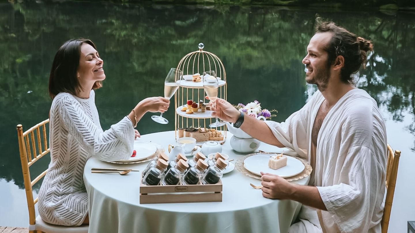 Couple enjoying Afternoon Tea by the lake at The Banjaran Hotsprings Retreat