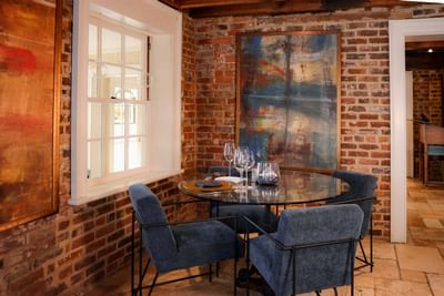 Chic dining area with a round glass table and blue chairs at the inn at Willow grove