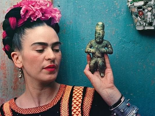 Frida Kahlo posing with a statue at Casa Mali by Dominion