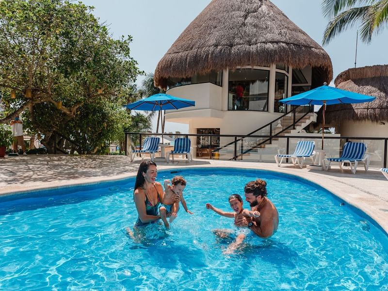 Family playing with their children in the pool of the Reef Playacar