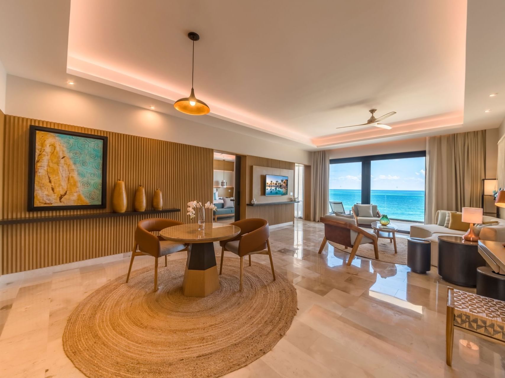 Dining table for two & living area with TV & comfy sofa in Master Suite Oceanfront at Haven Riviera Cancun