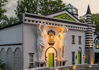 The Roxbury exterior features large white sculptures with modern architecture and vibrant green accents