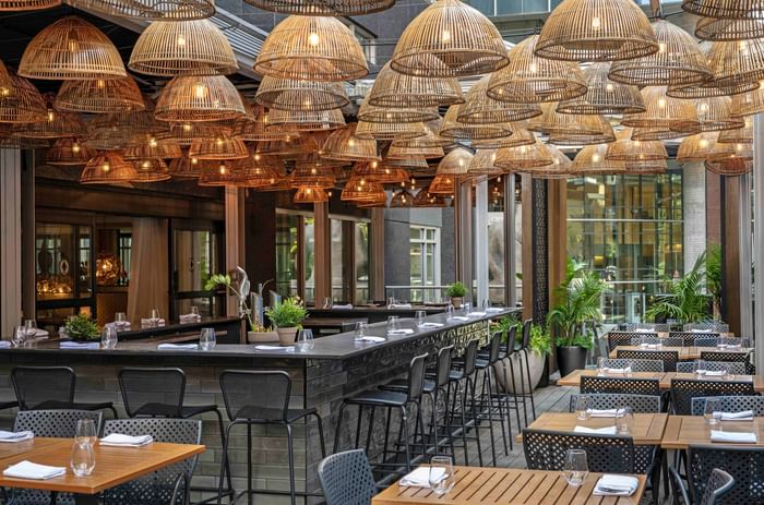 Le bar extérieur chic et élégant avec des lanternes en rotin suspendues au Warwick Le Crystal Montréal