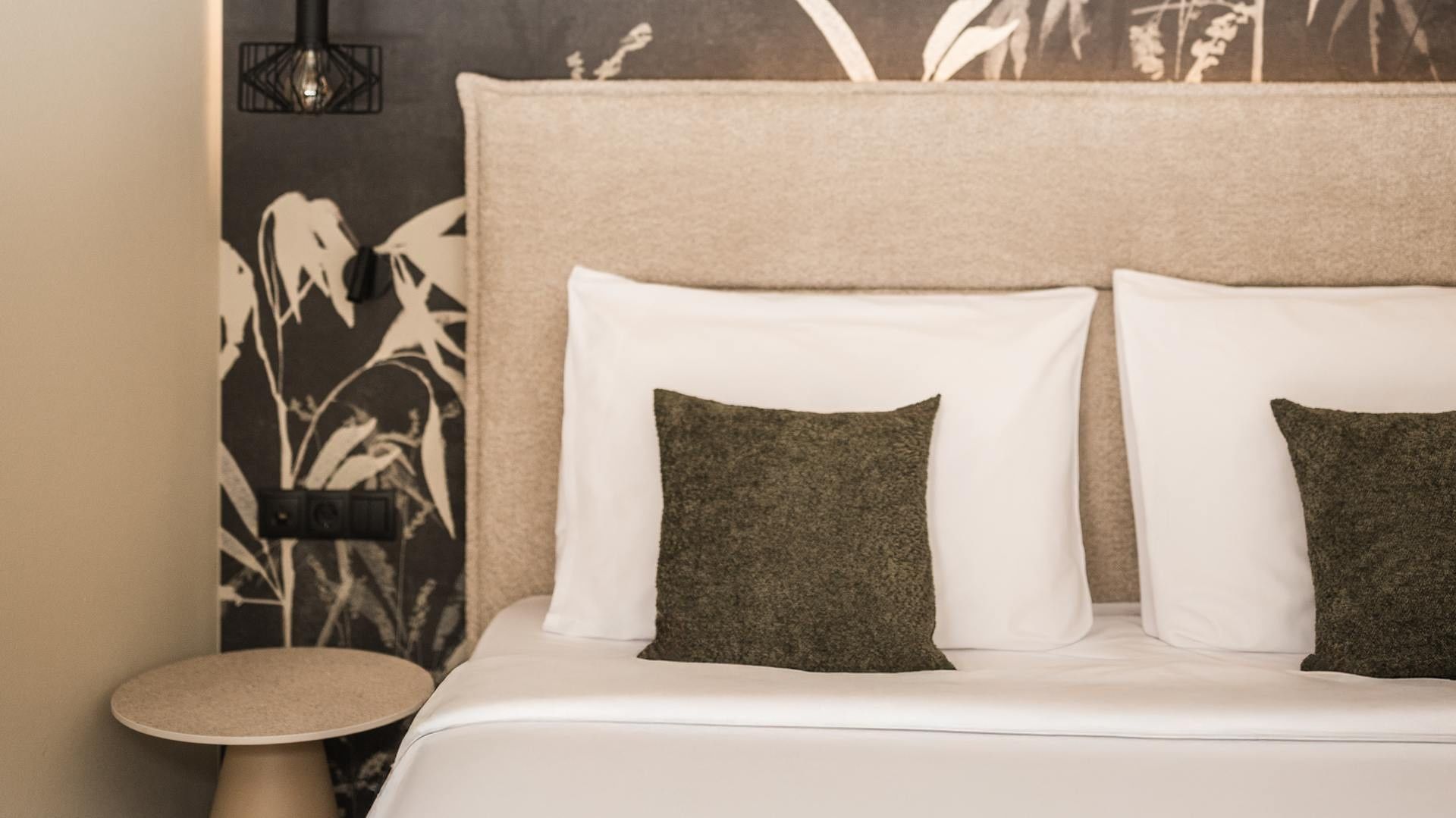 Camera doppia foresta con letti e cuscini al Falkensteiner Hotel Antholz.