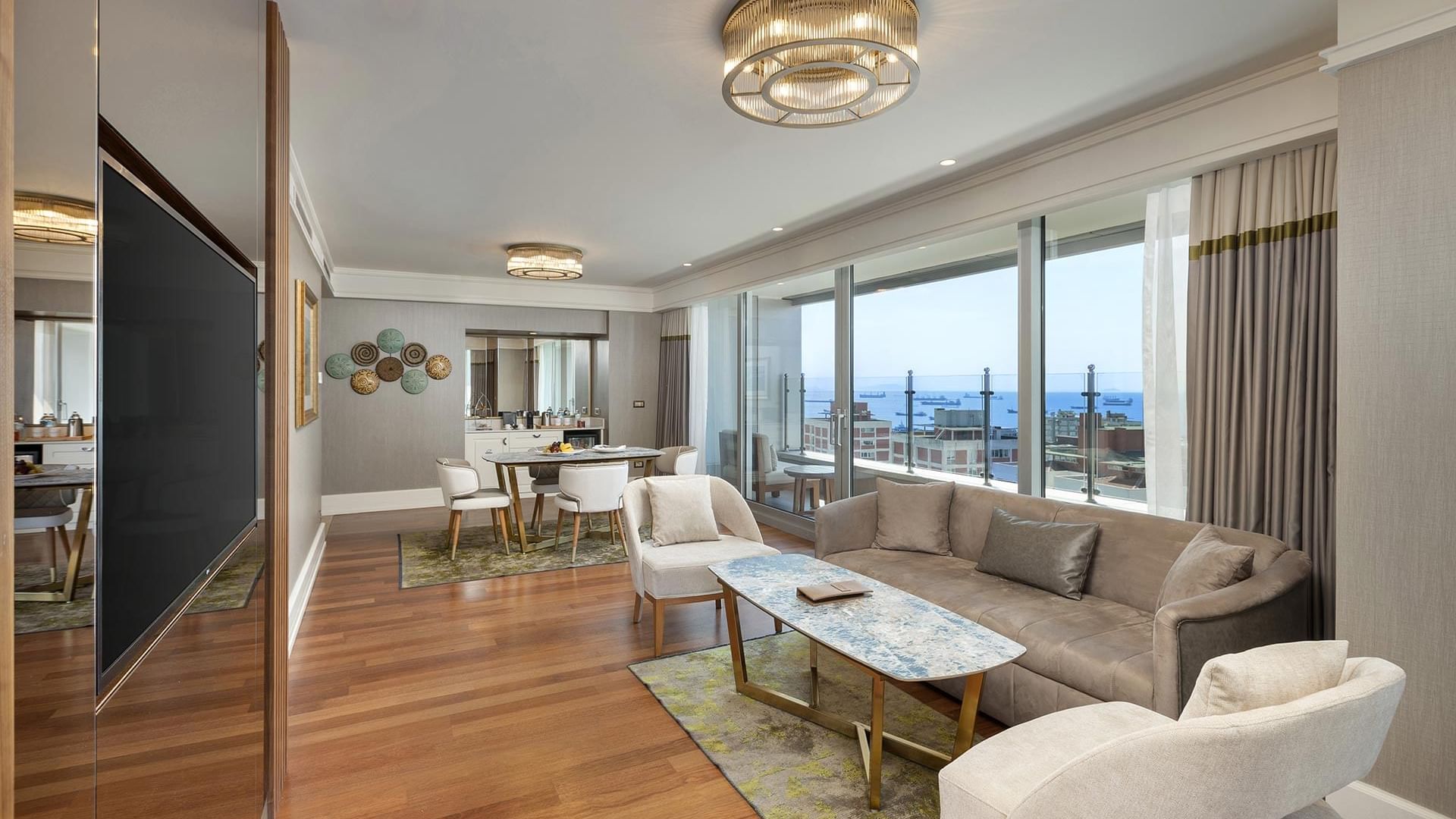 Living room with dining & sitting area with TV in One-bedroom Sea View Suite at Titanic Port Bakirkoy