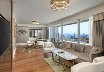 Living room with dining & sitting area with TV in One-bedroom Sea View Suite at Titanic Port Bakirkoy