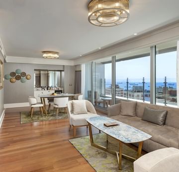 Living room with dining & sitting area with TV in One-bedroom Sea View Suite at Titanic Port Bakirkoy