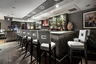Bar area with bar stools at Artmore Hotel