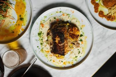 Beautifully plated grilled fish served over creamy vegetables at Cypress & Oak, one of the best restaurants in Frankfort, KY