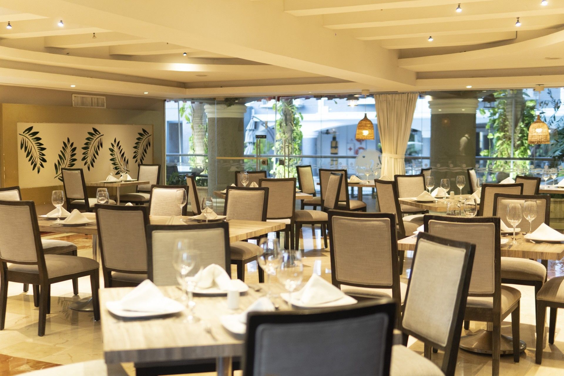 Elegant and well-lit interior of the main restaurant at the Country International Hotel set with dining tables and glasses