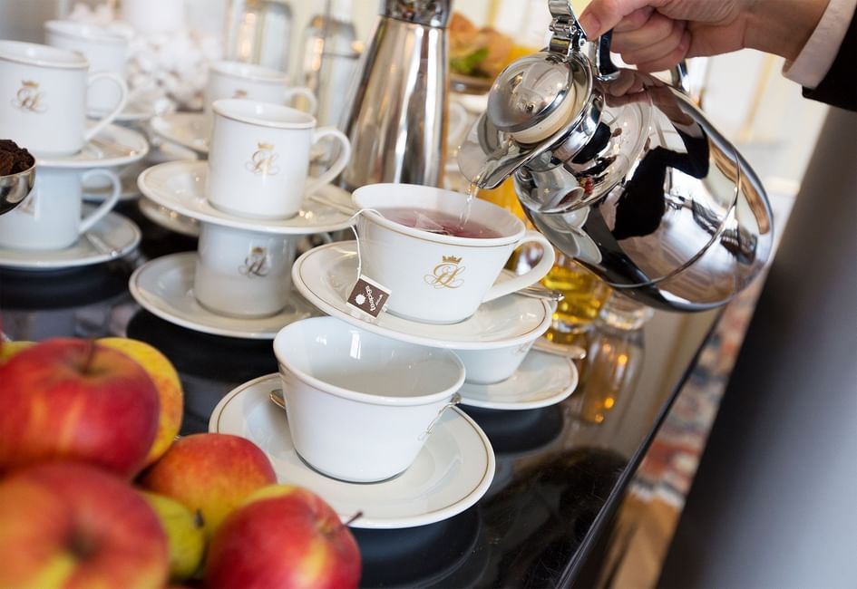 Closeup of a lady serving tea at Hotel Grand Lund