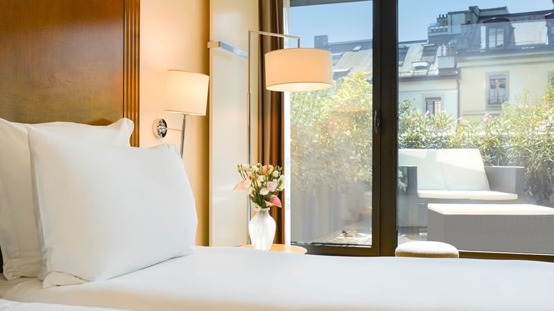 Bed & balcony lounge area in Classic Terrace Room at Warwick Geneva