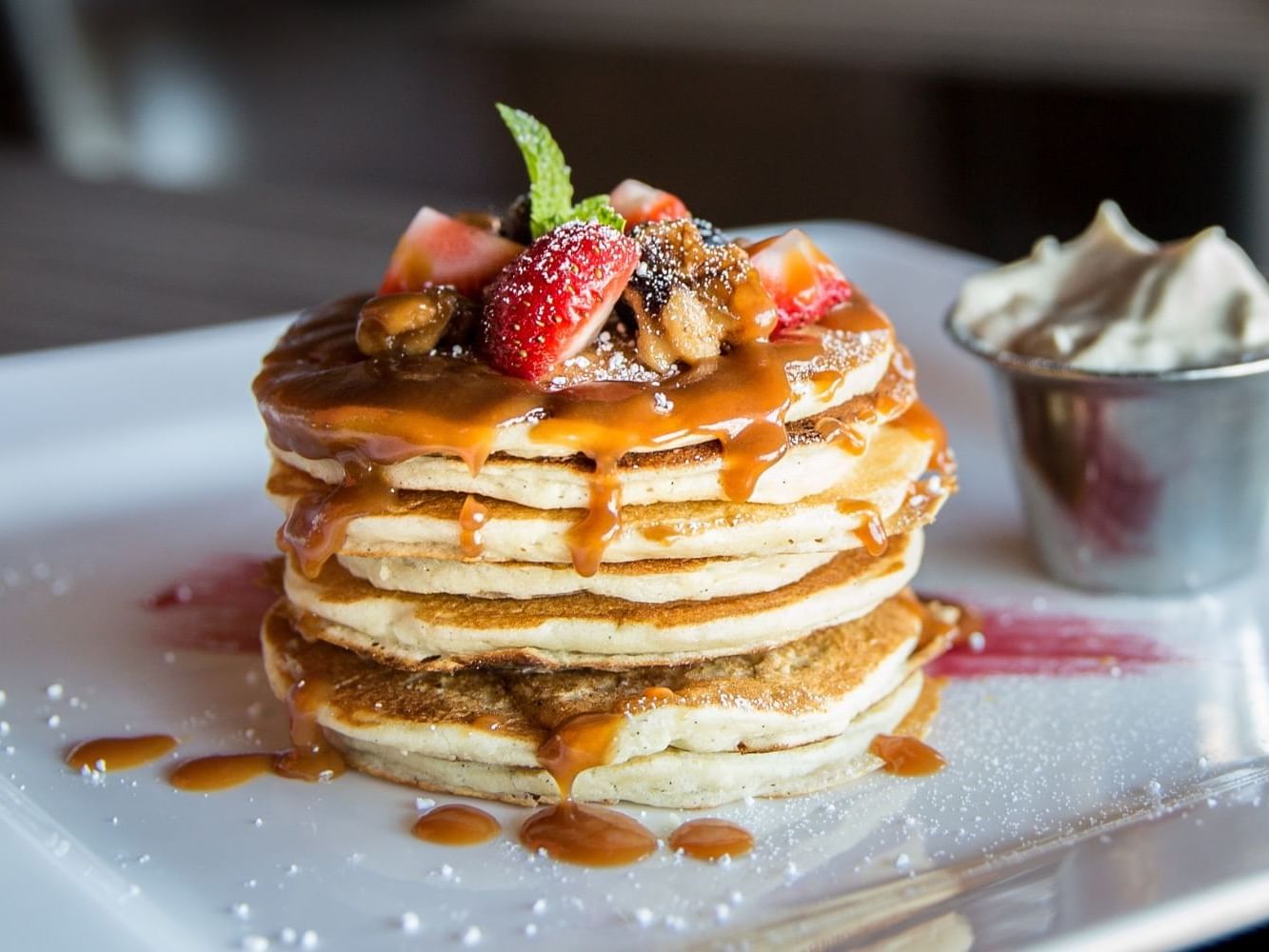 Fluffy pancakes with berries served with honey and cream in Raspberri’s at Ogunquit River Inn