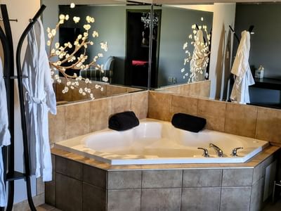 Modern bathtub featuring vanity products in Romantic Spa Suites at Service Plus Inns & Suites Drayton Valley