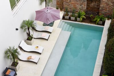 Piscina exterior con hamacas en Argenta Suites Belgrano