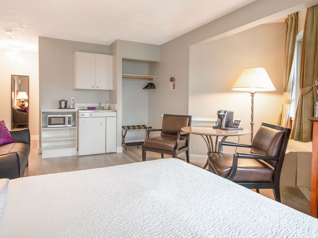 A hotel studio suite with queen bed and kitchenette