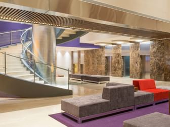 Modern hotel lobby featuring a spiral staircase and purple accent rugs at Camino Real Pedregal Mexico