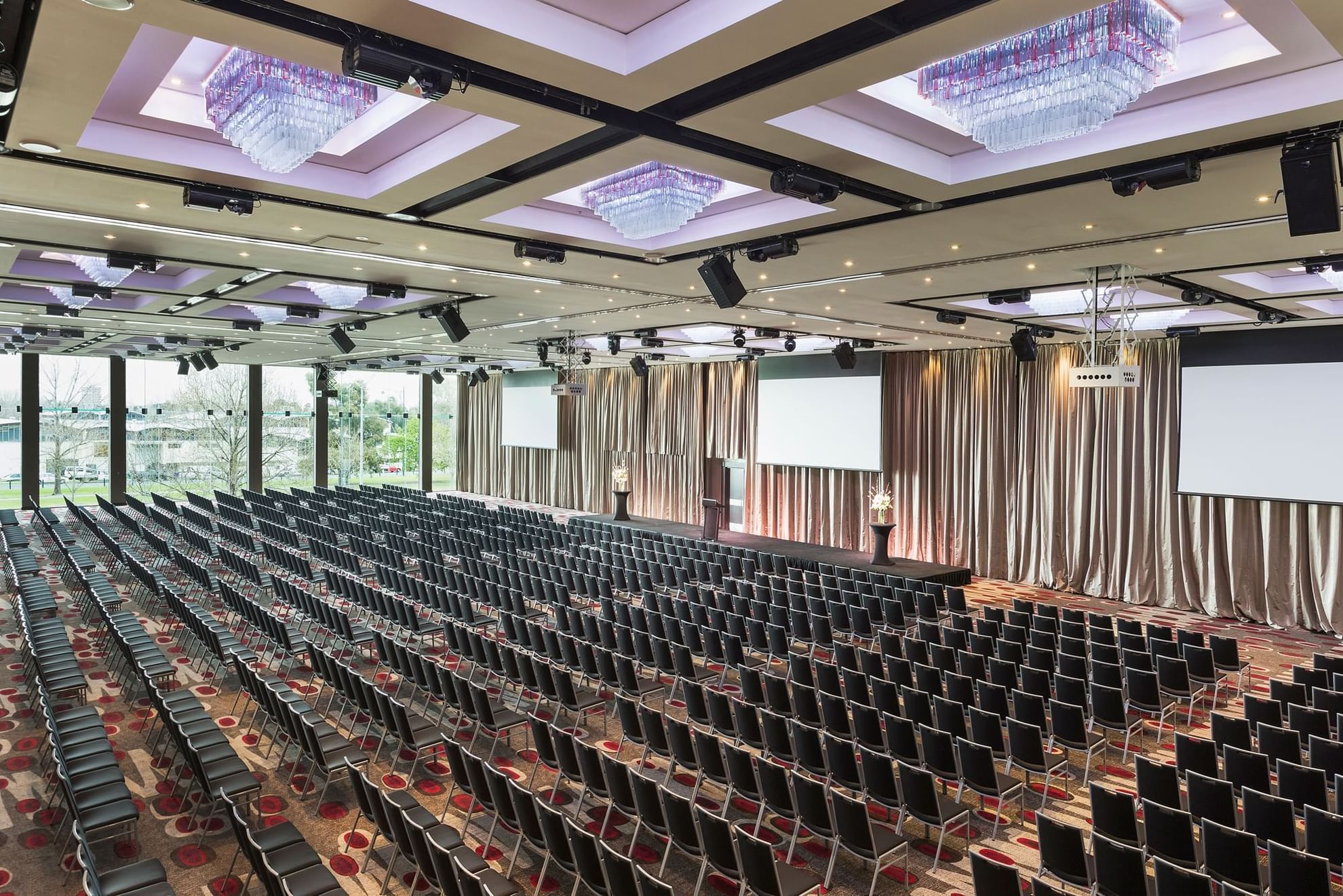 Theatre set-up in Grand Ballroom with screens and carpeted floors at Pullman Albert Park