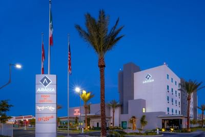 Exterior night view with flag poles at Araiza San Luis