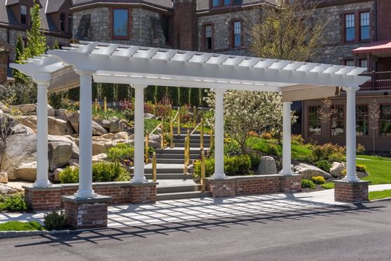 A white pergola in the gardens at The Abbey Inn