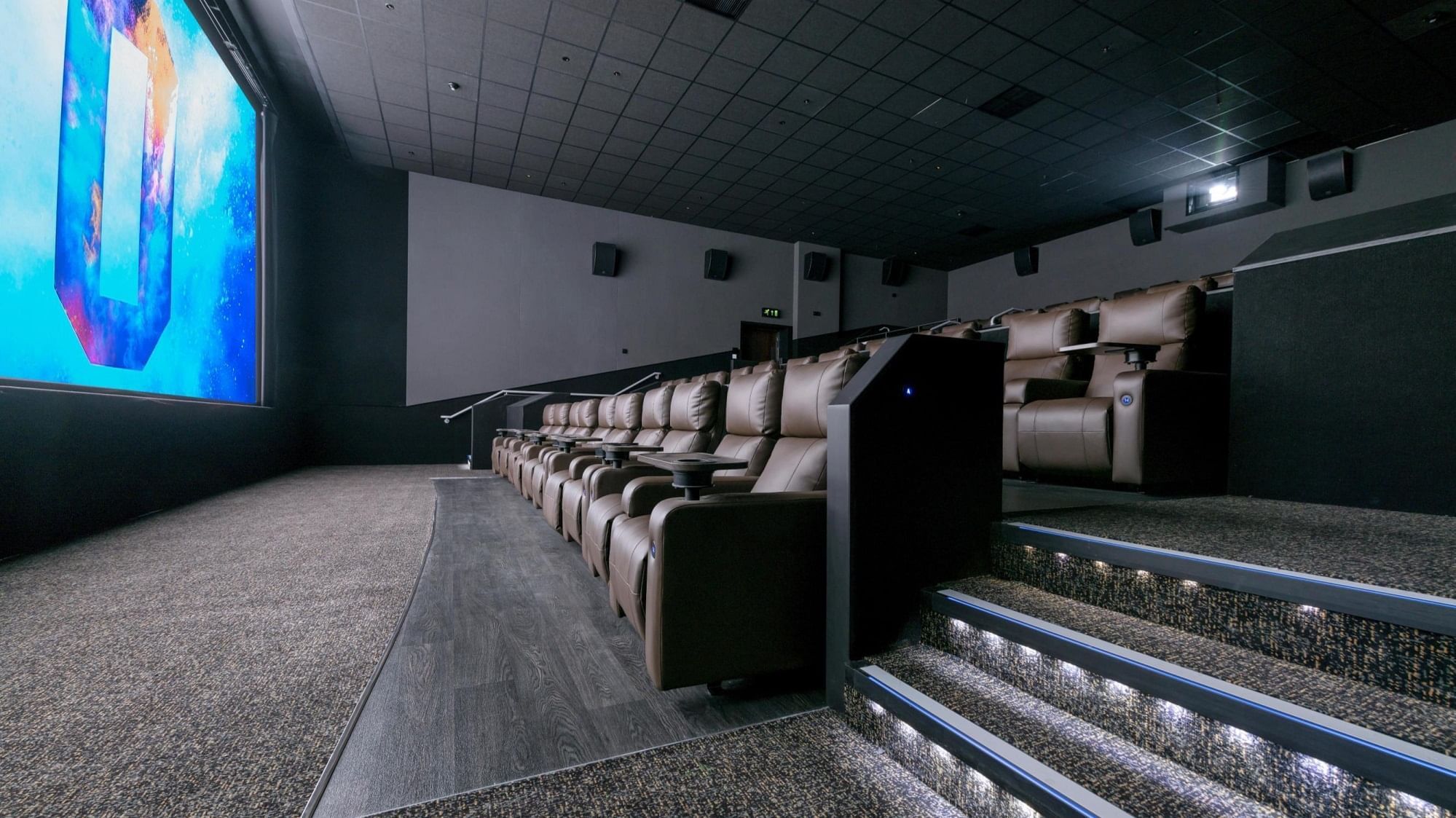 A spacious movie theater with comfortable seats and a large screen near The Londoner Hotel