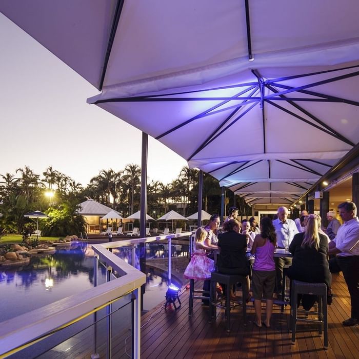 Celsius Restaurant & Bar by the pool with guests under large umbrellas at Mercure Hotel Townsville