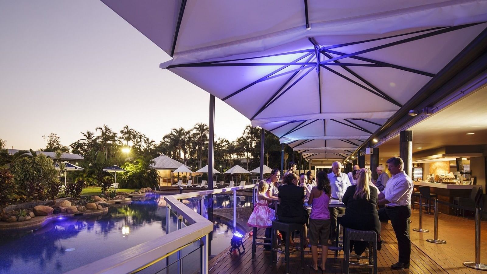 Celsius Restaurant & Bar by the pool with guests under large umbrellas at Mercure Hotel Townsville