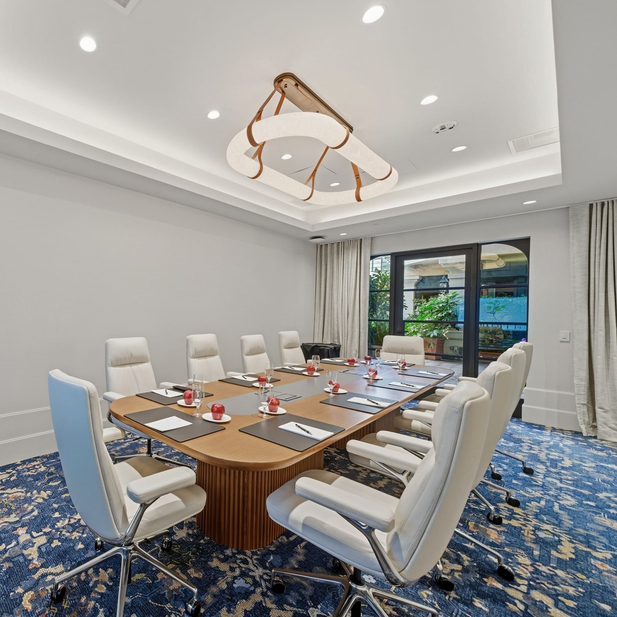 White chairs around a conference table in a meeting room at El Prado Palo Alto