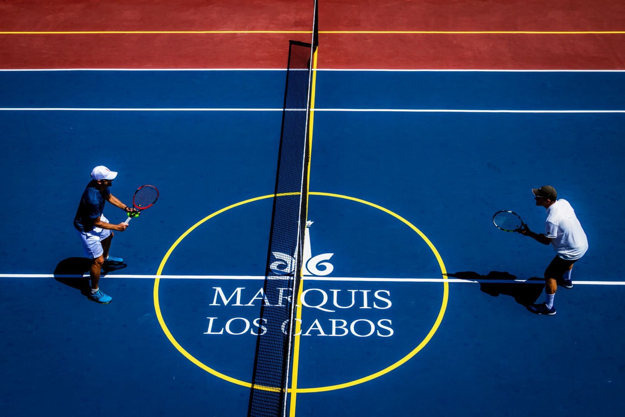 Top view of 2 people playing tennis at Marquis Los Cabos